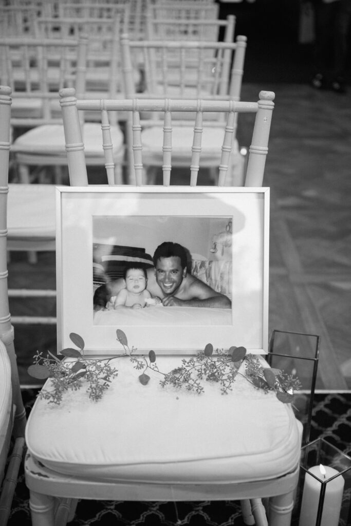 a photo frame of bride and dad before his passing on a ceremony chair